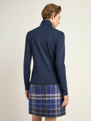 Frau in blauer Jacke und kariertem Rock von hinten