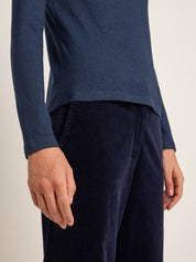 Person trägt blaues Oberteil und Cordhose