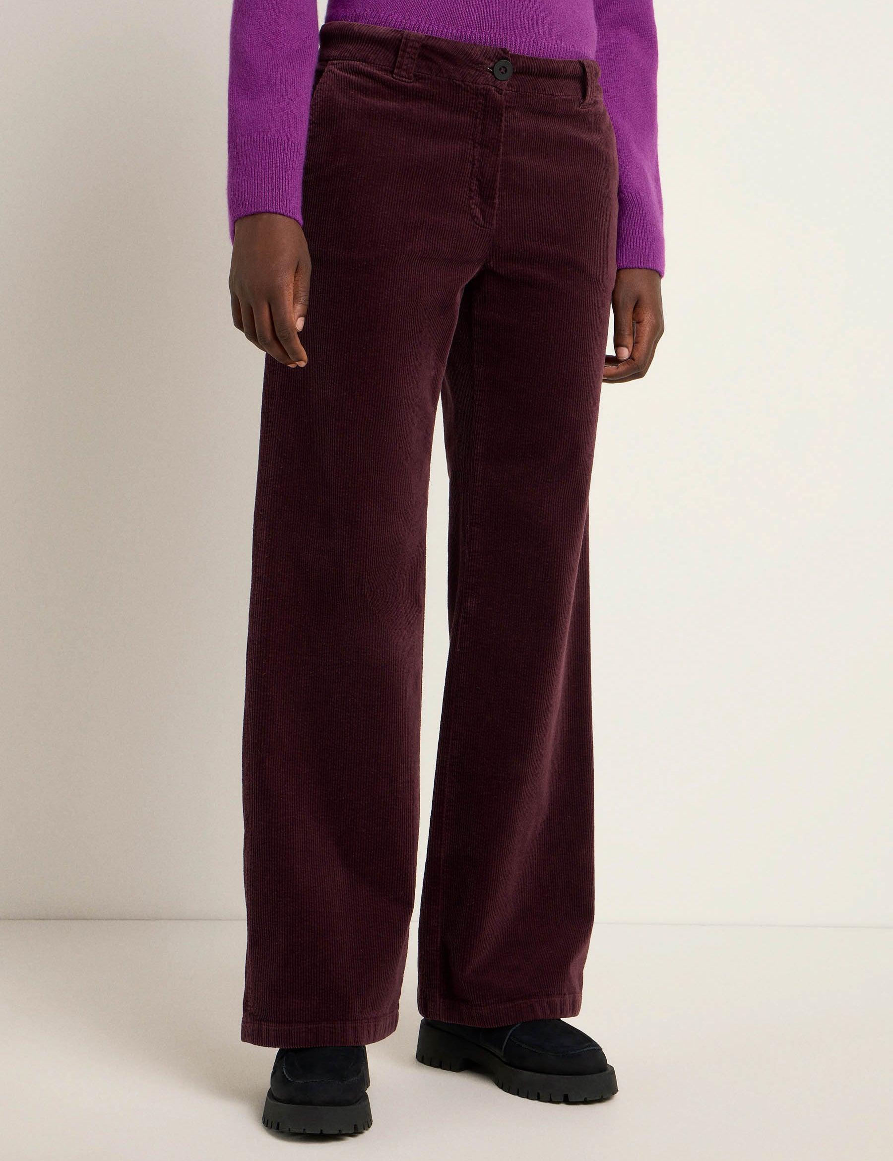 Person trägt lila Cordhose und Pullover
