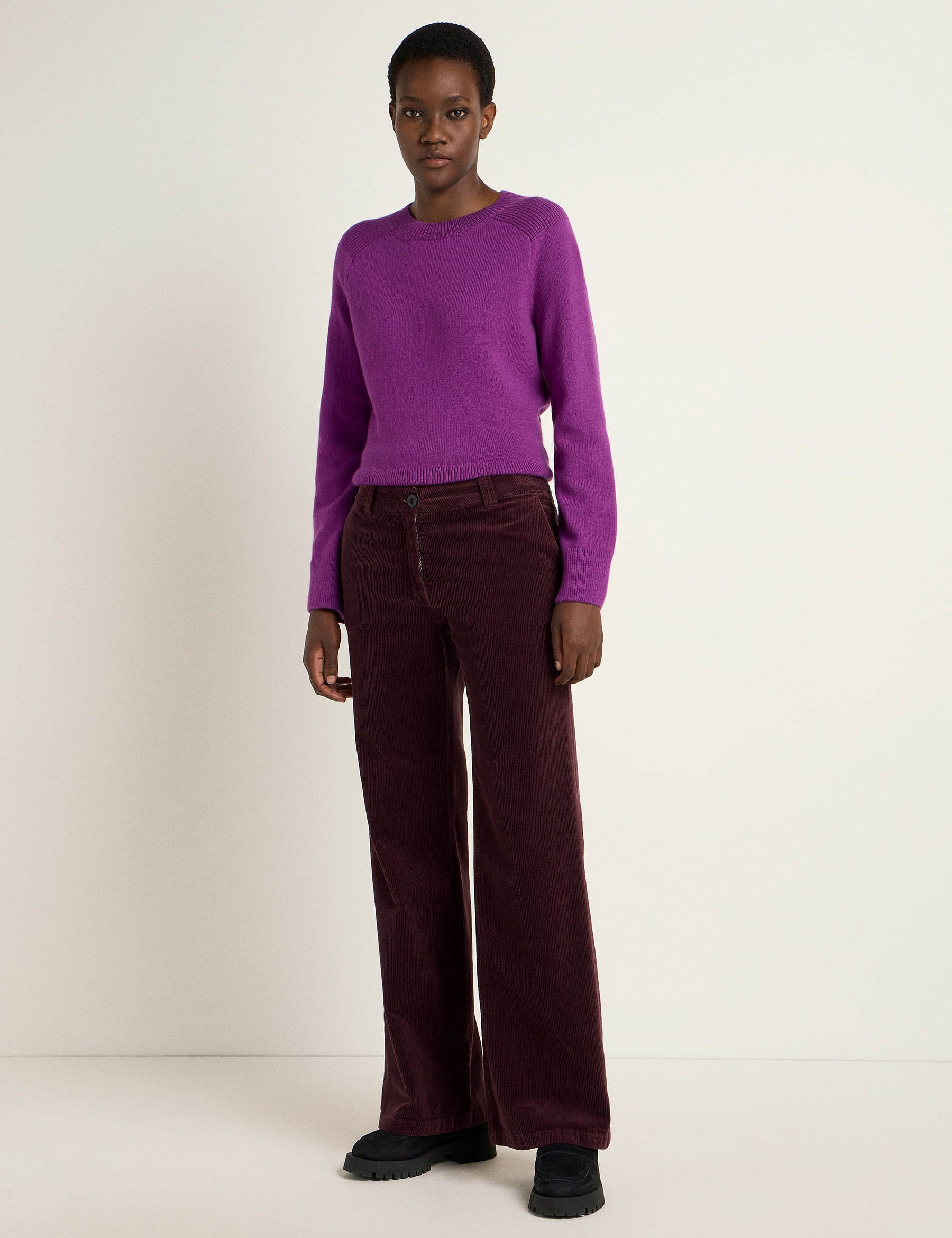 Frau in lila Pullover und bordeaux Hosen