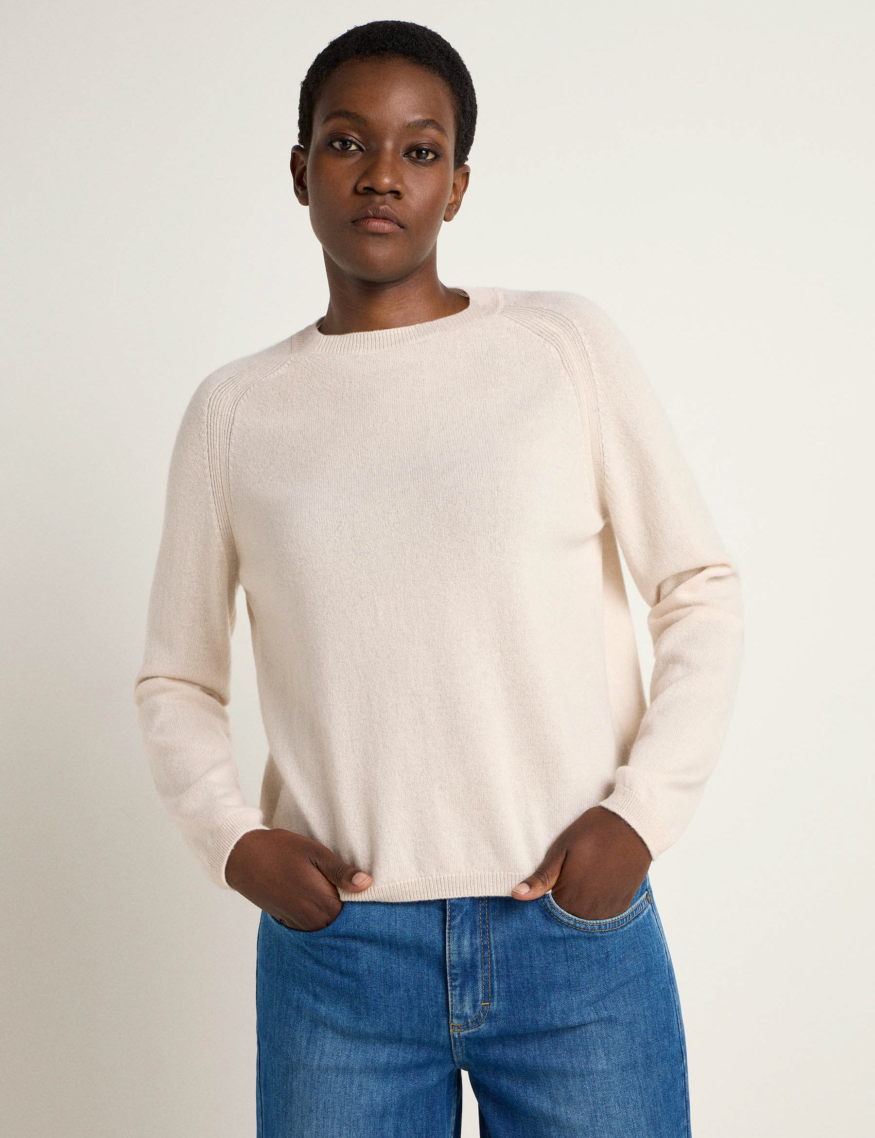 Frau in weißem Pullover und Jeans