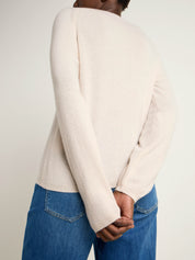 Person trägt weißen Pullover und Jeans