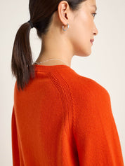 Frau in orangem Pullover von hinten