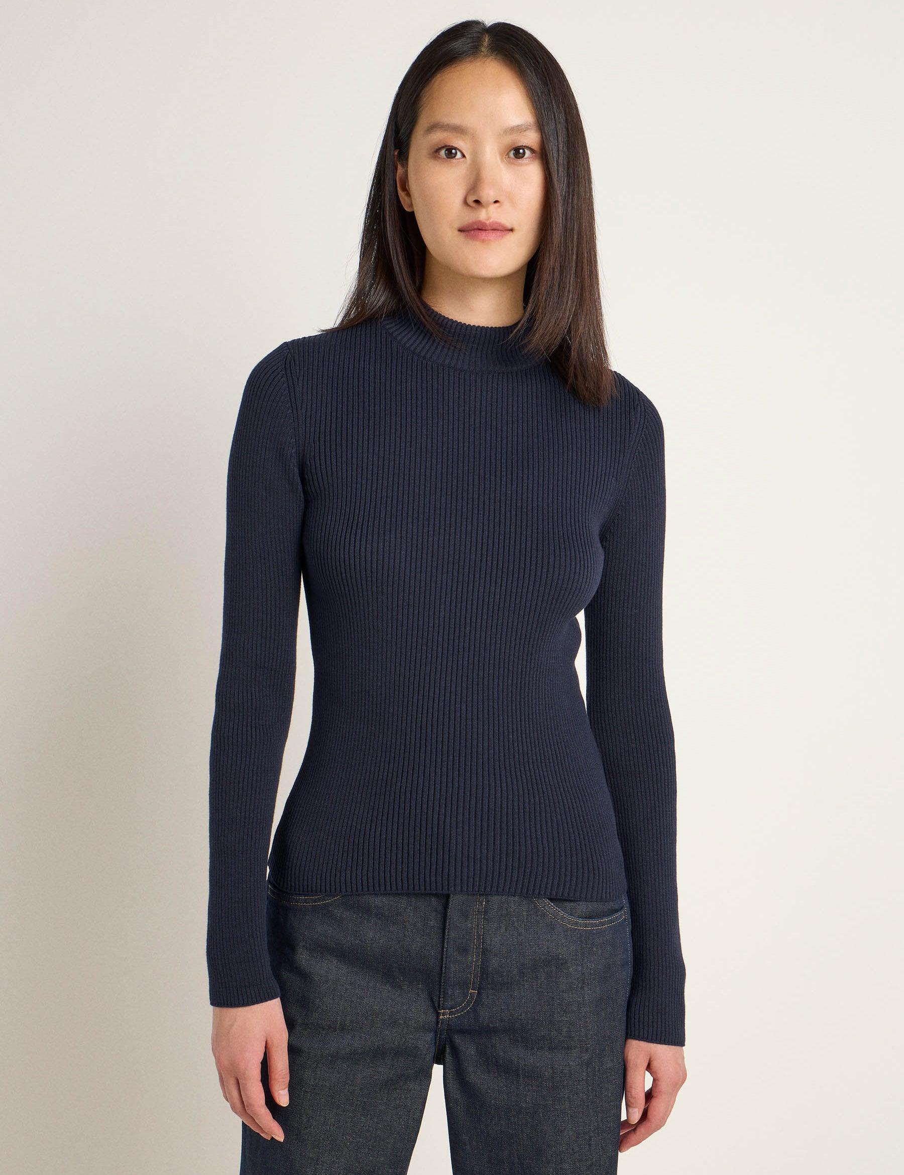 Frau in blauem Rollkragenpullover und Jeans