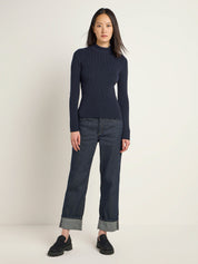 Frau in blauem Rollkragenpullover und Jeans