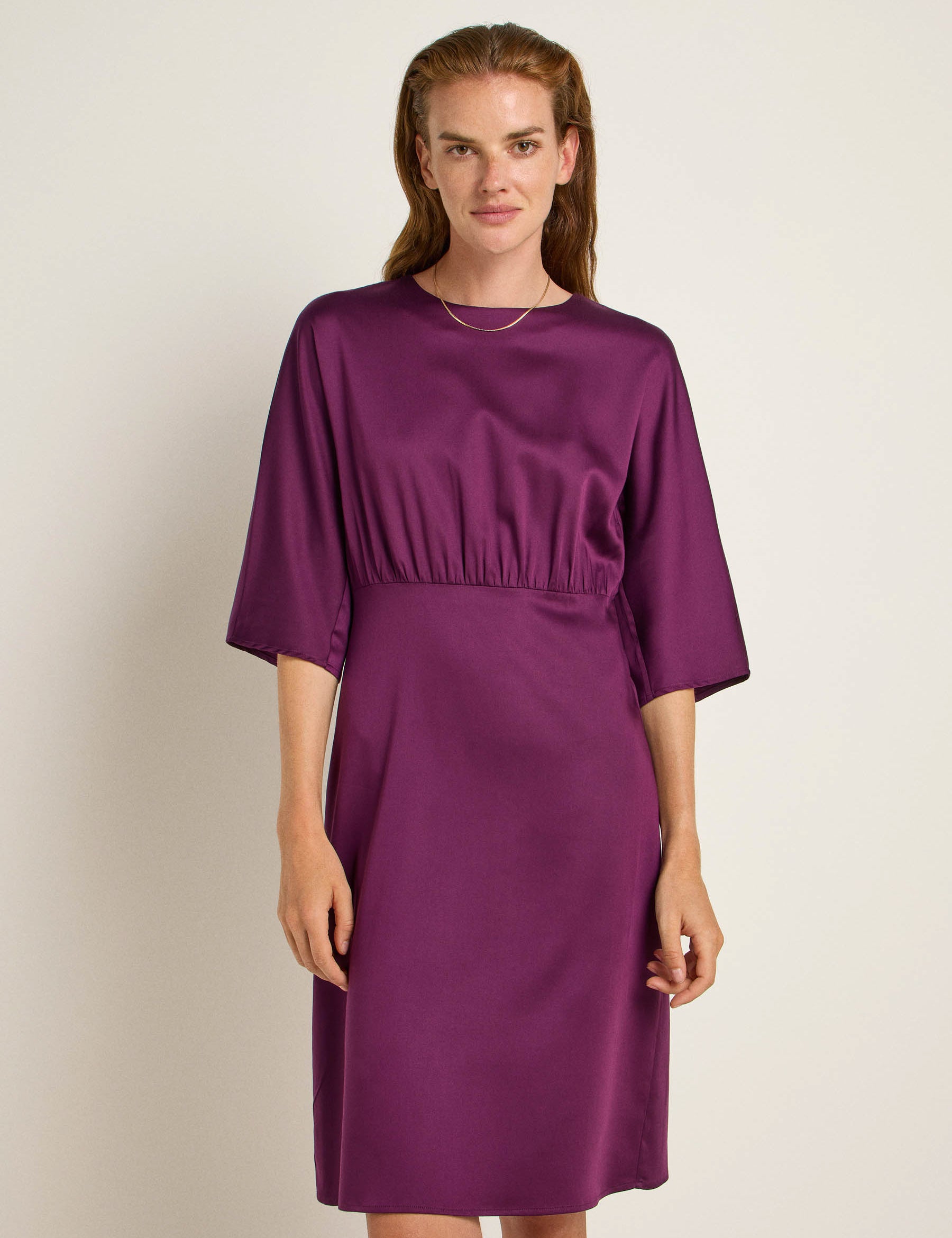 Frau in elegantem purpurfarbenem Kleid