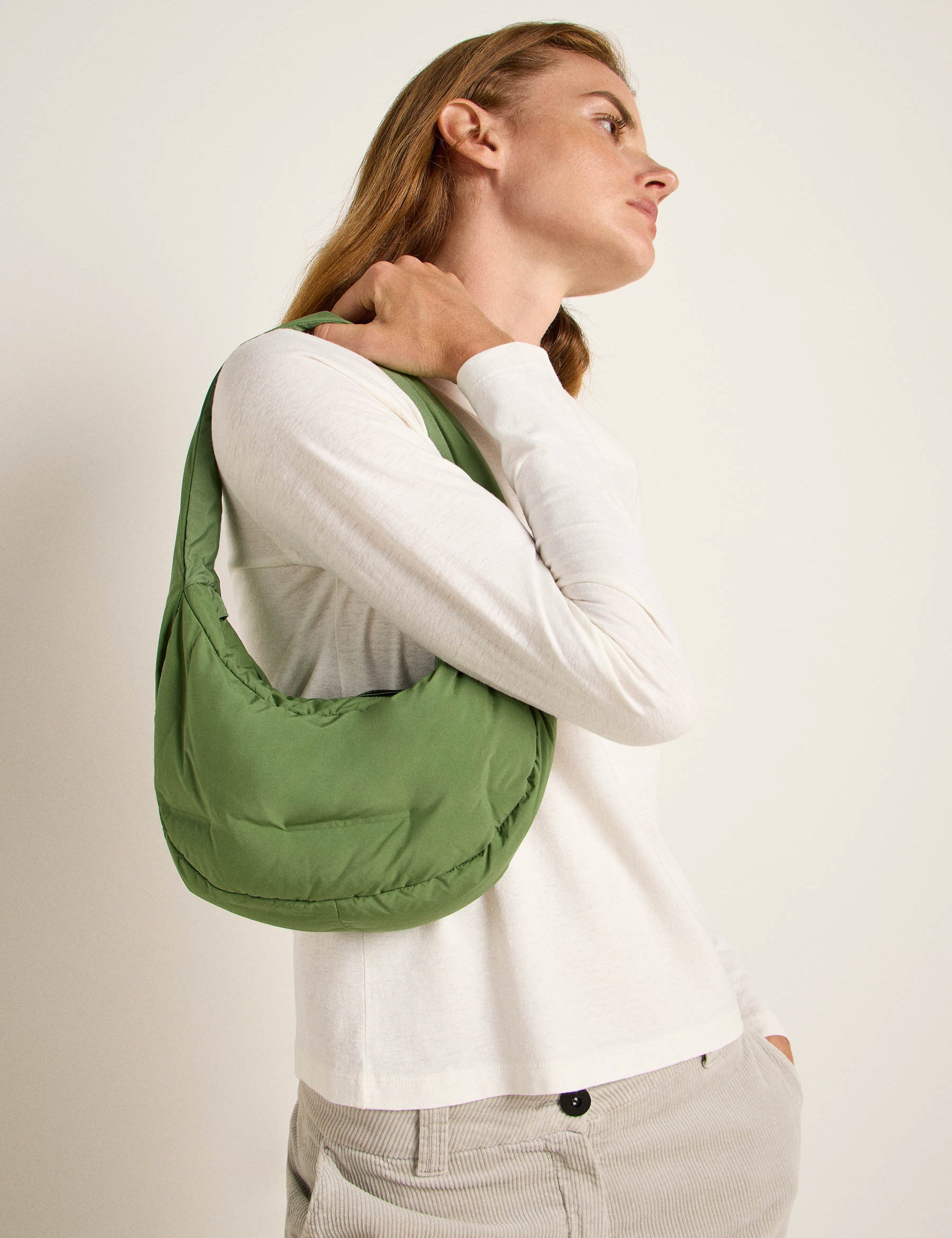 Frau mit grüner Schultertasche seitlich