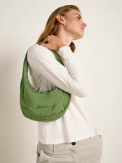 Frau mit grüner Schultertasche seitlich