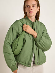 Mann in grüner Jacke posiert
