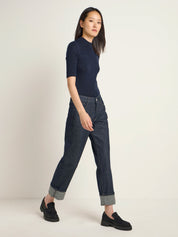 Frau in blauem Shirt und Jeans steht