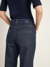 Person trägt dunkle Jeans und blaues Shirt