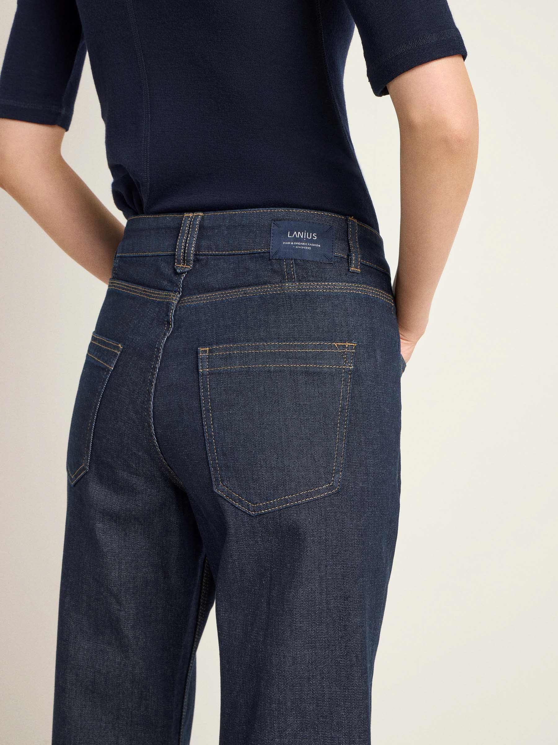 Person trägt dunkle Jeans und blaues Shirt