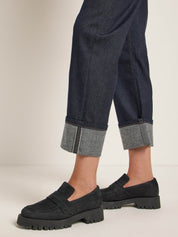 Person trägt Jeans und schwarze Plateauschuhe