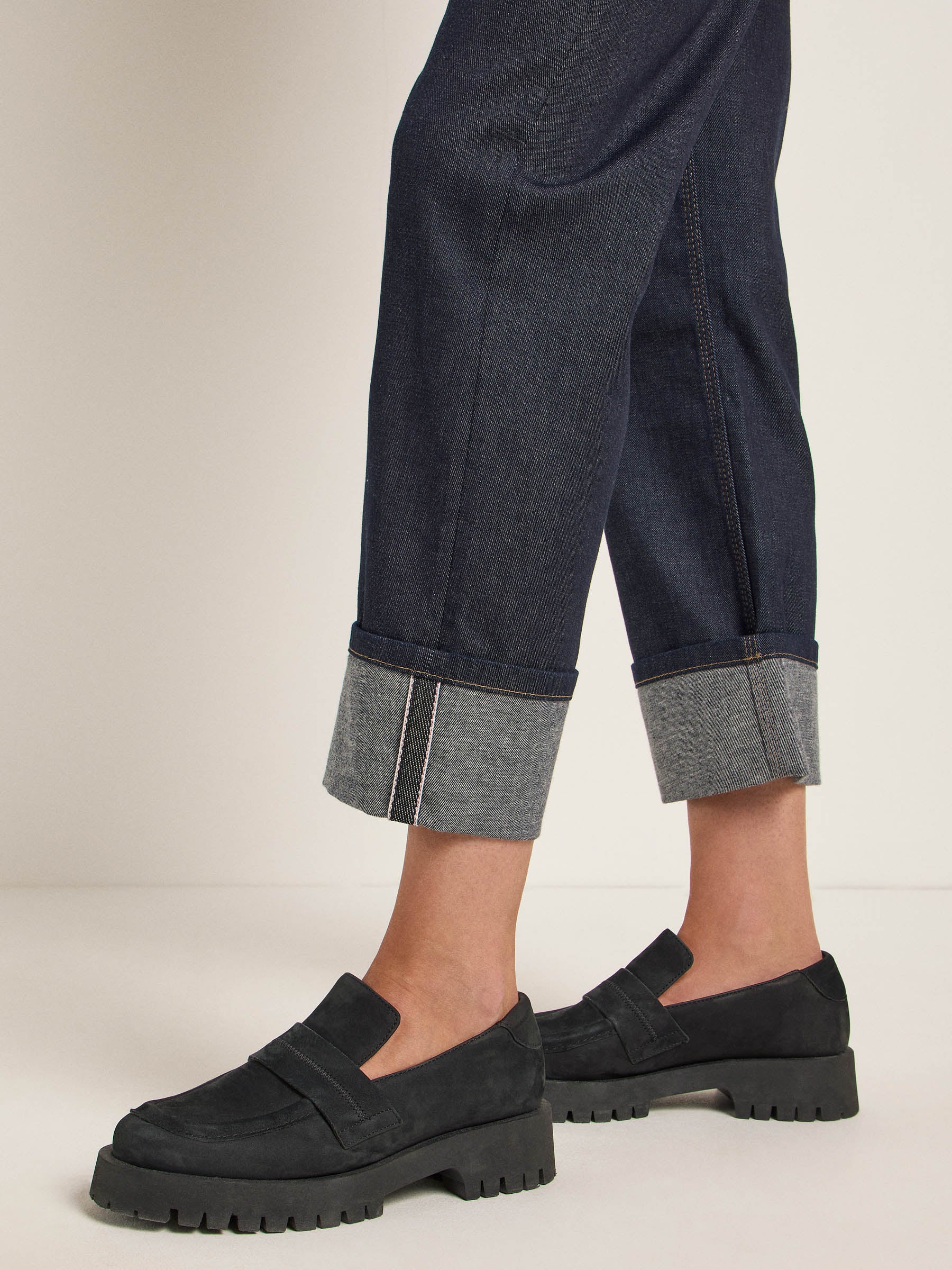 Person trägt Jeans und schwarze Plateauschuhe