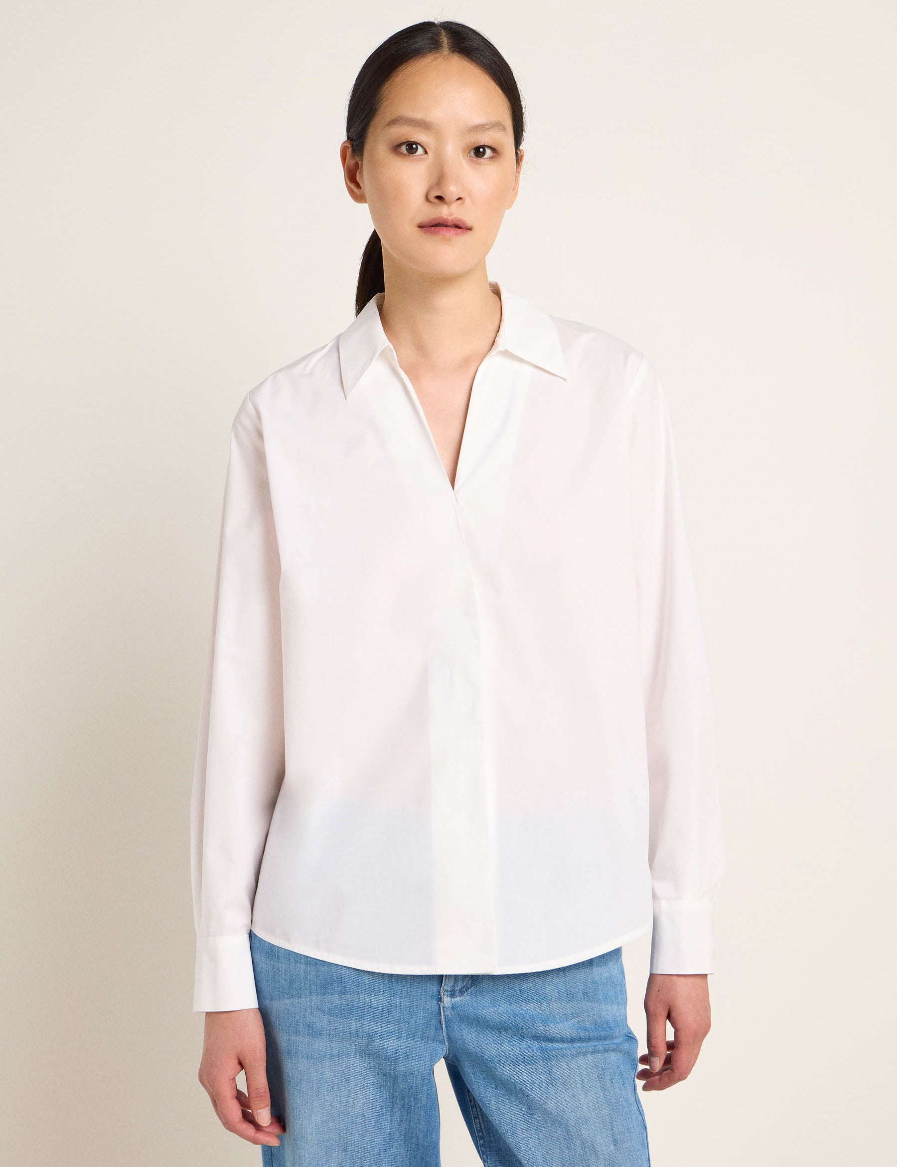Frau in weißer Bluse und blauen Jeans