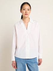 Frau in weißer Bluse und blauen Jeans