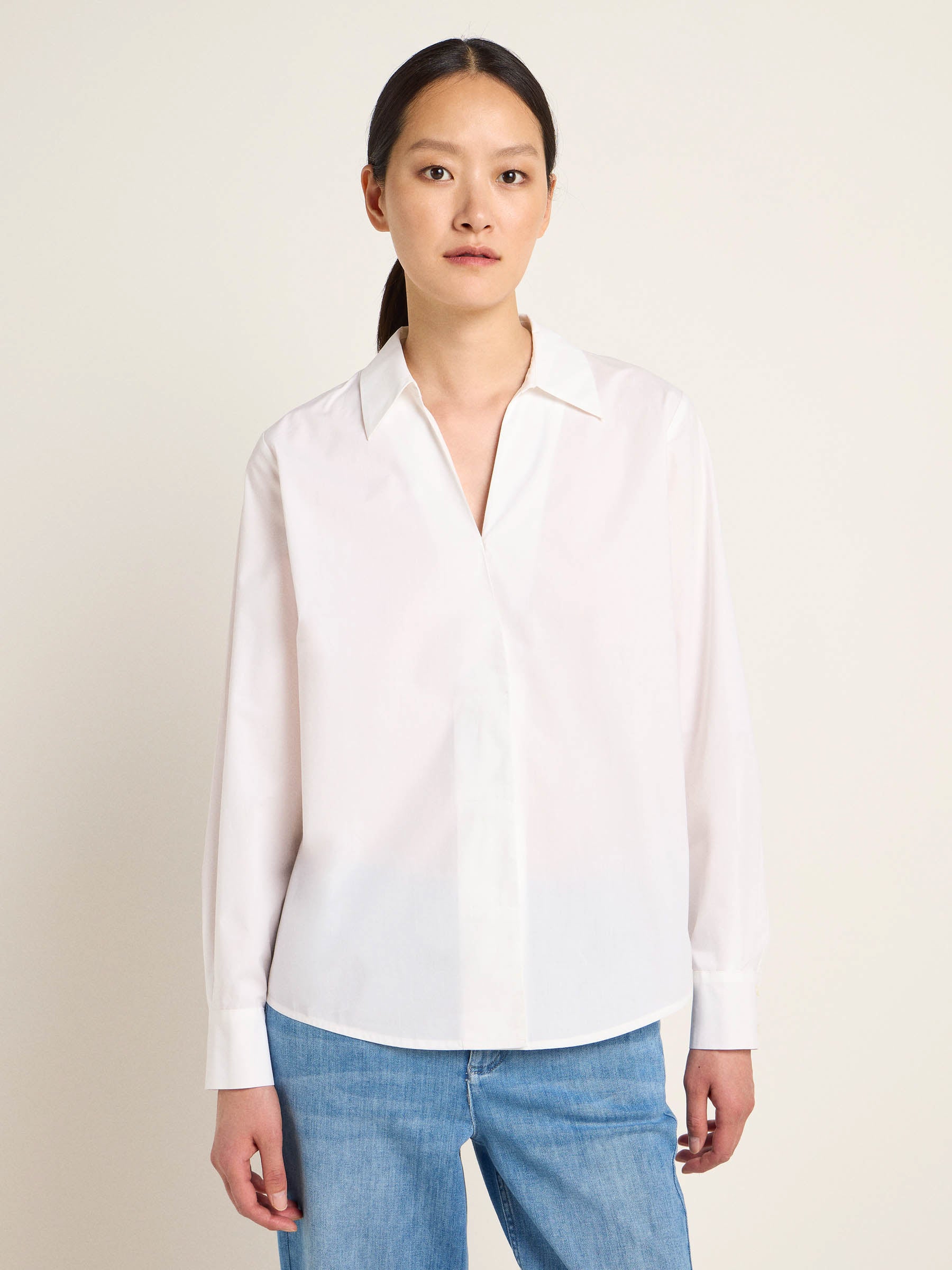 Frau in weißer Bluse und blauen Jeans