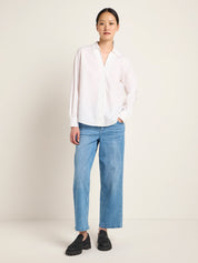 Frau in weißer Bluse und blauen Jeans