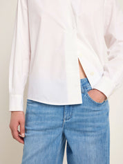 Person trägt weiße Bluse und Jeans