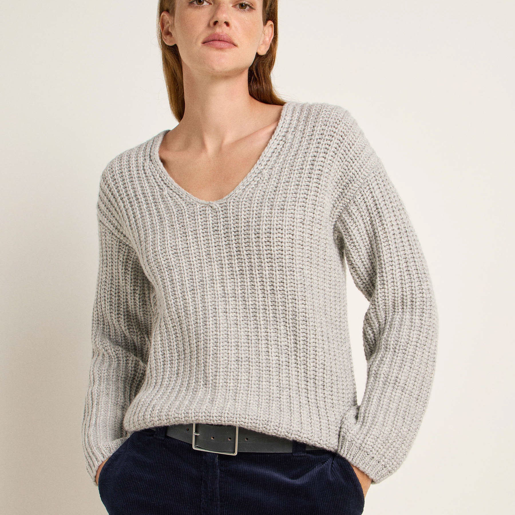 Frau in grauem Pullover und blauen Jeans