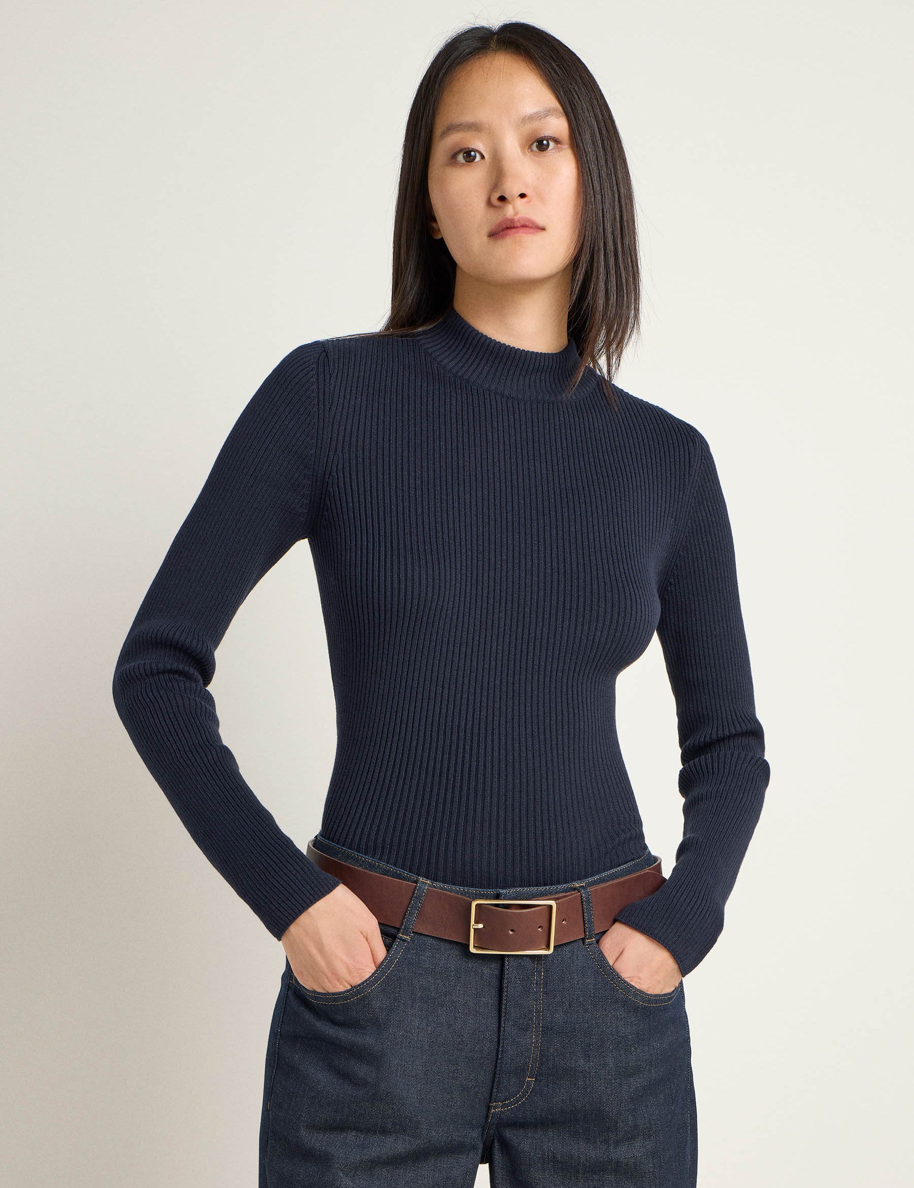 Frau in blauem Rollkragenpullover und Jeans