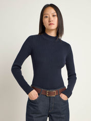 Frau in blauem Rollkragenpullover und Jeans
