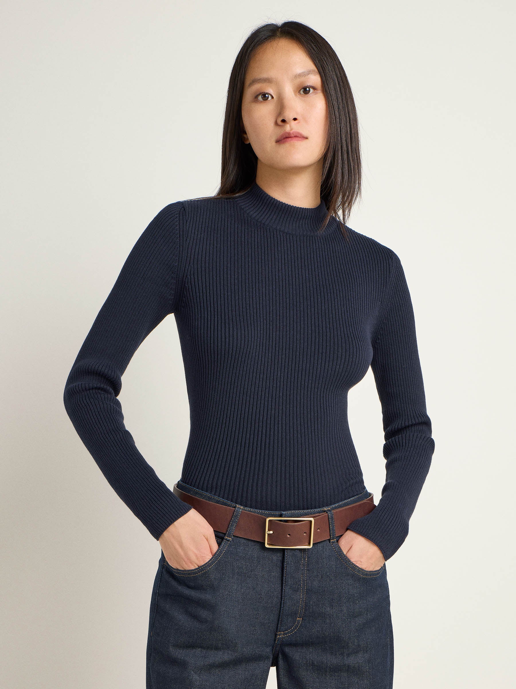 Frau in blauem Rollkragenpullover und Jeans