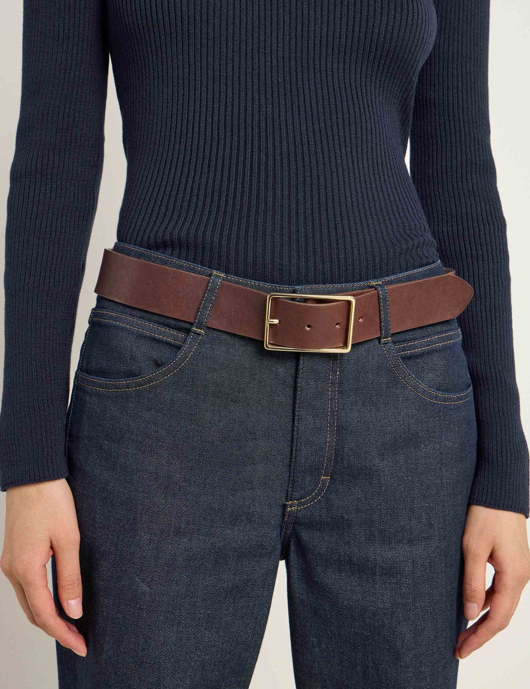 Frau mit Jeans und braunem Gürtel