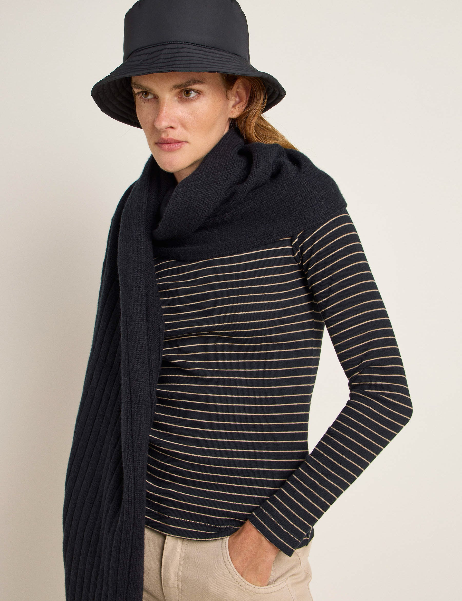 Frau mit Hut, Streifenshirt und Strickschal