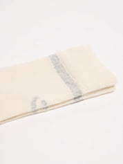 Gefaltete helle Stoffdecke mit grauen Streifen