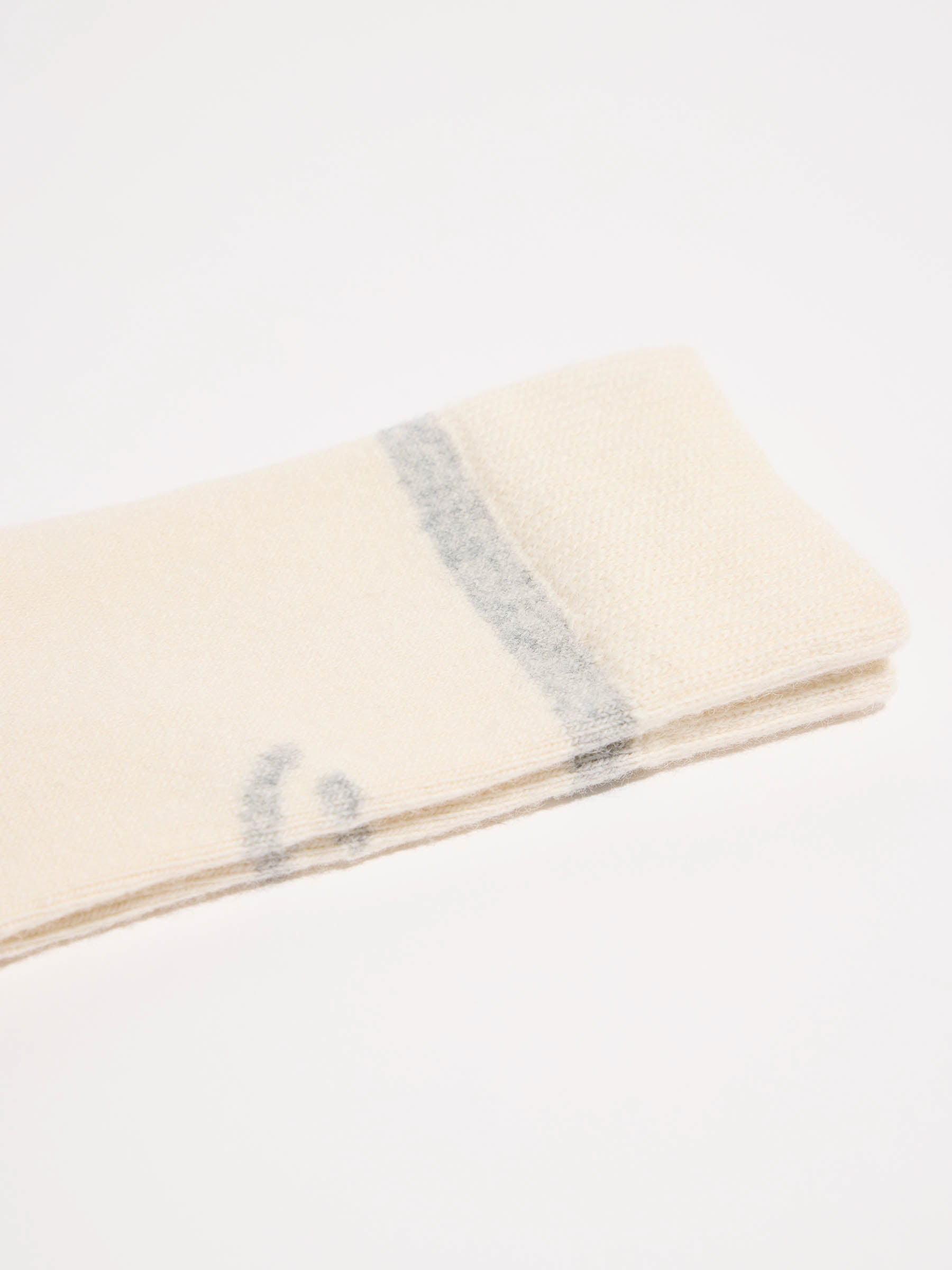 Gefaltete helle Stoffdecke mit grauen Streifen