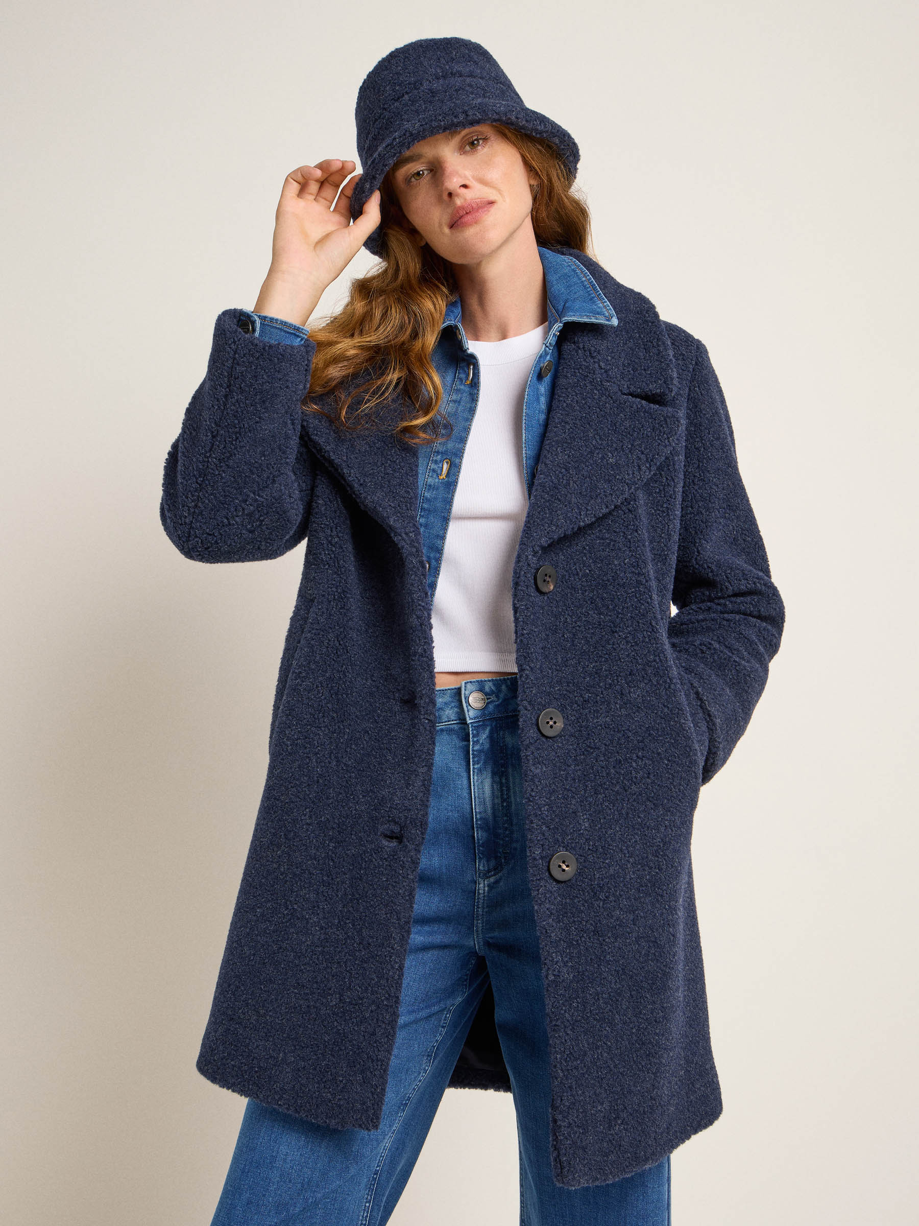 Frau in blauem Mantel und passendem Hut