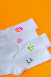 Weiße Socken mit bunten Stickereien auf orange