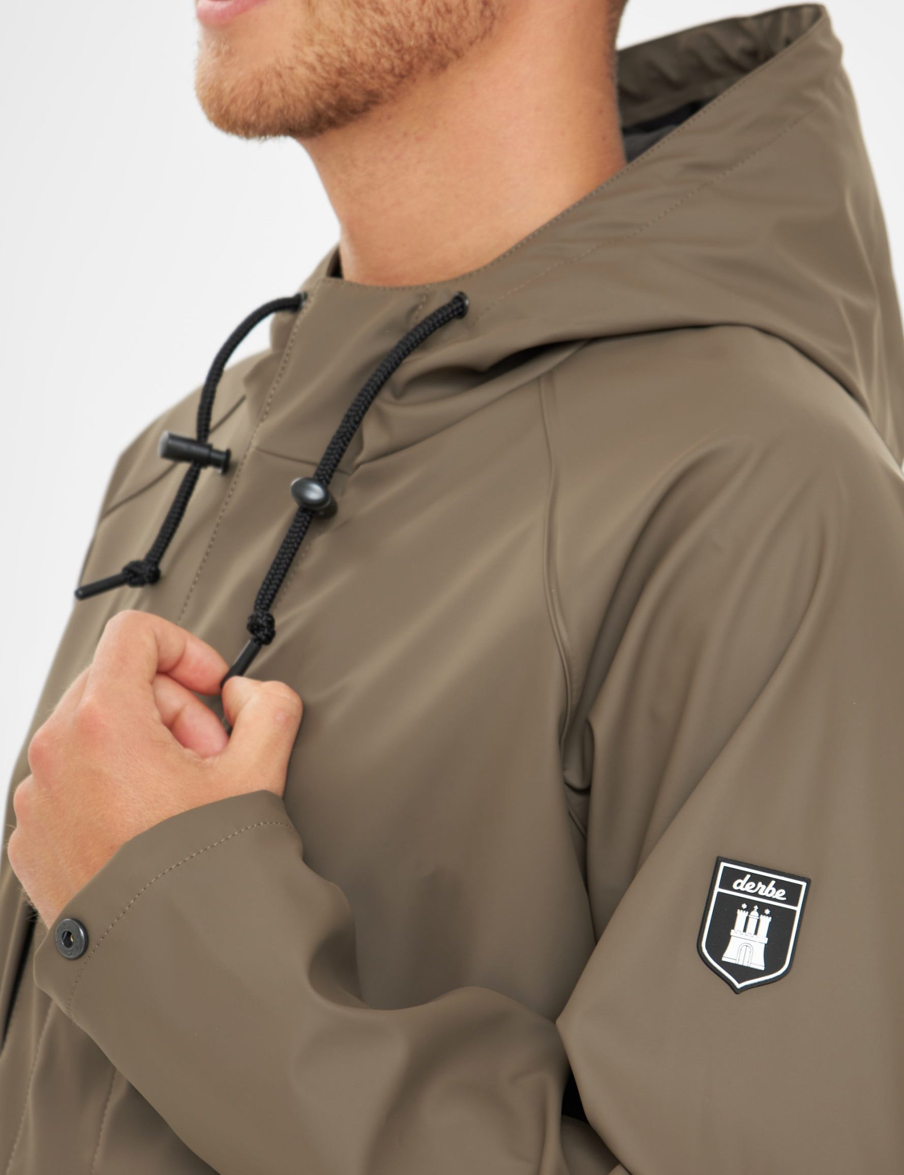 Mann in olivgrüner Jacke mit Logo