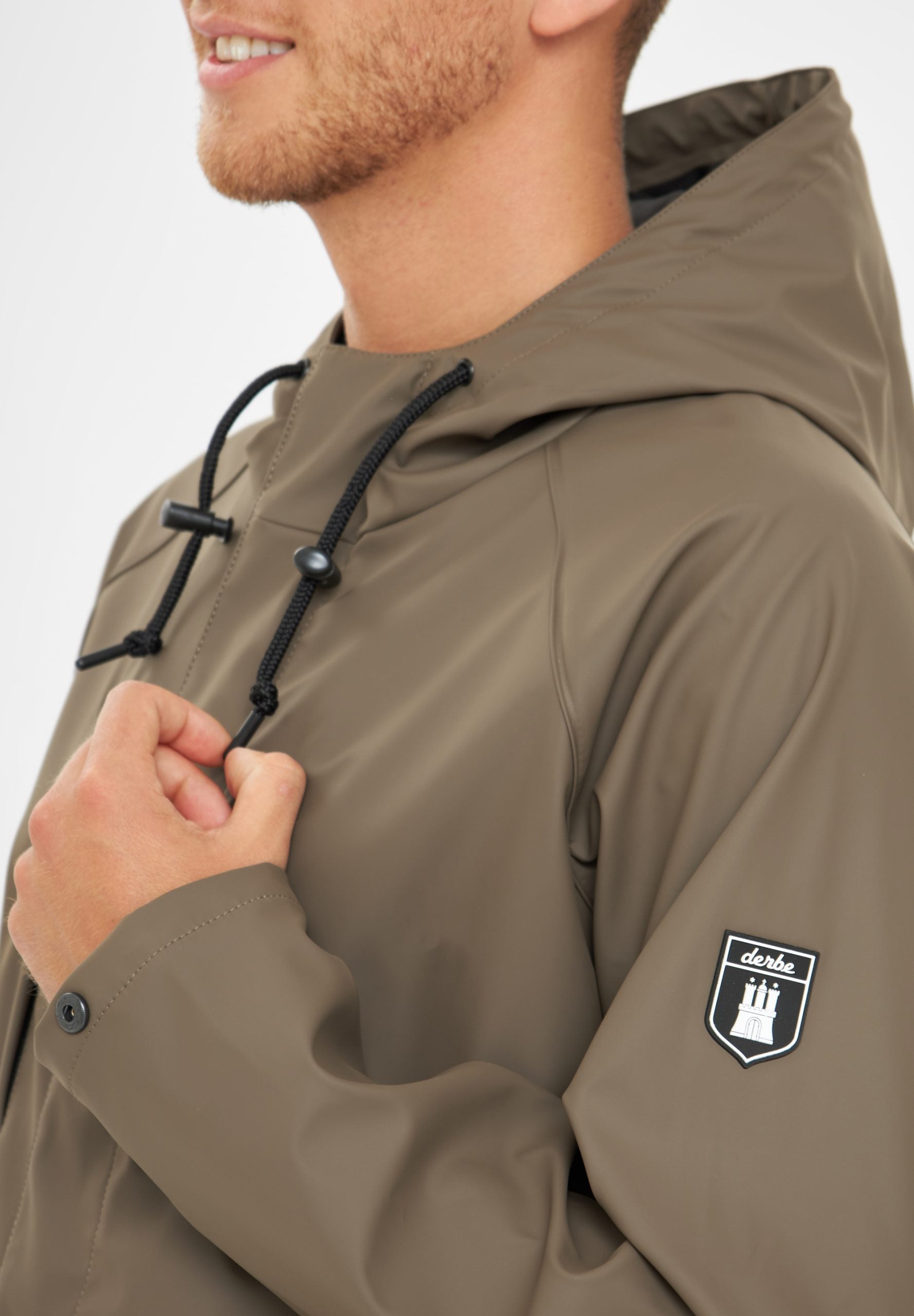 Mann in olivgrüner Jacke mit Logo