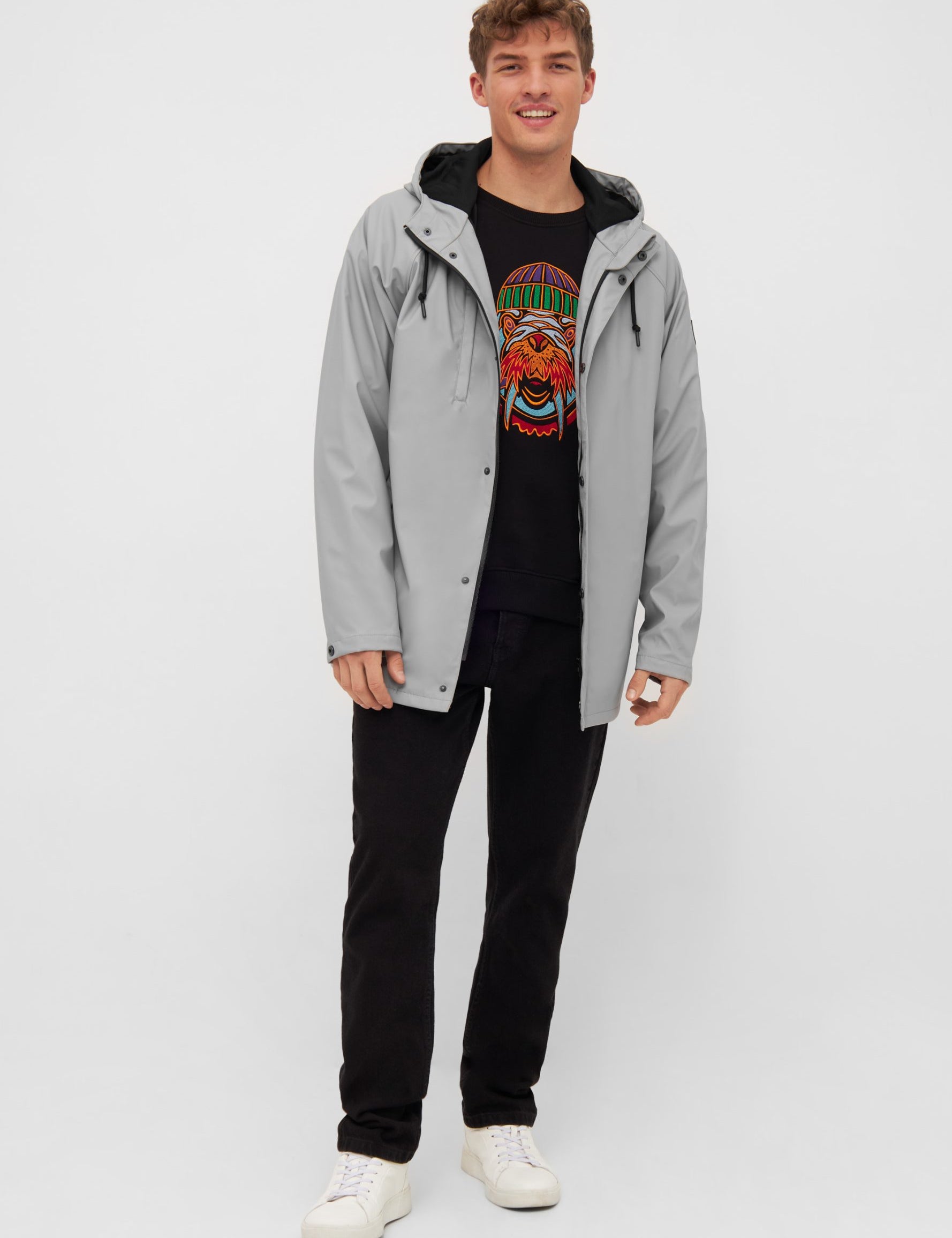 Mann in grauer Jacke und bedrucktem T-Shirt