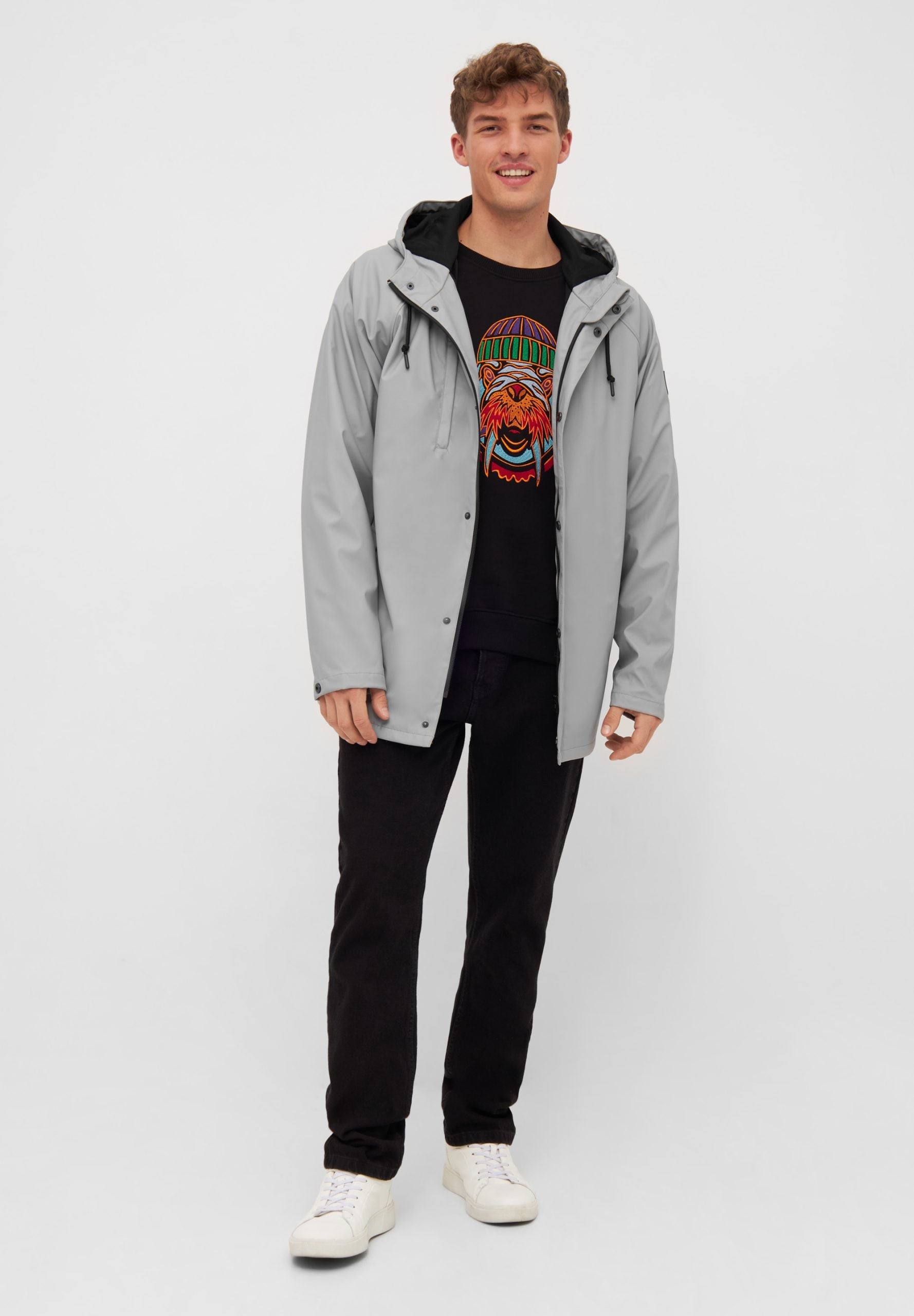 Mann in grauer Jacke und bedrucktem T-Shirt
