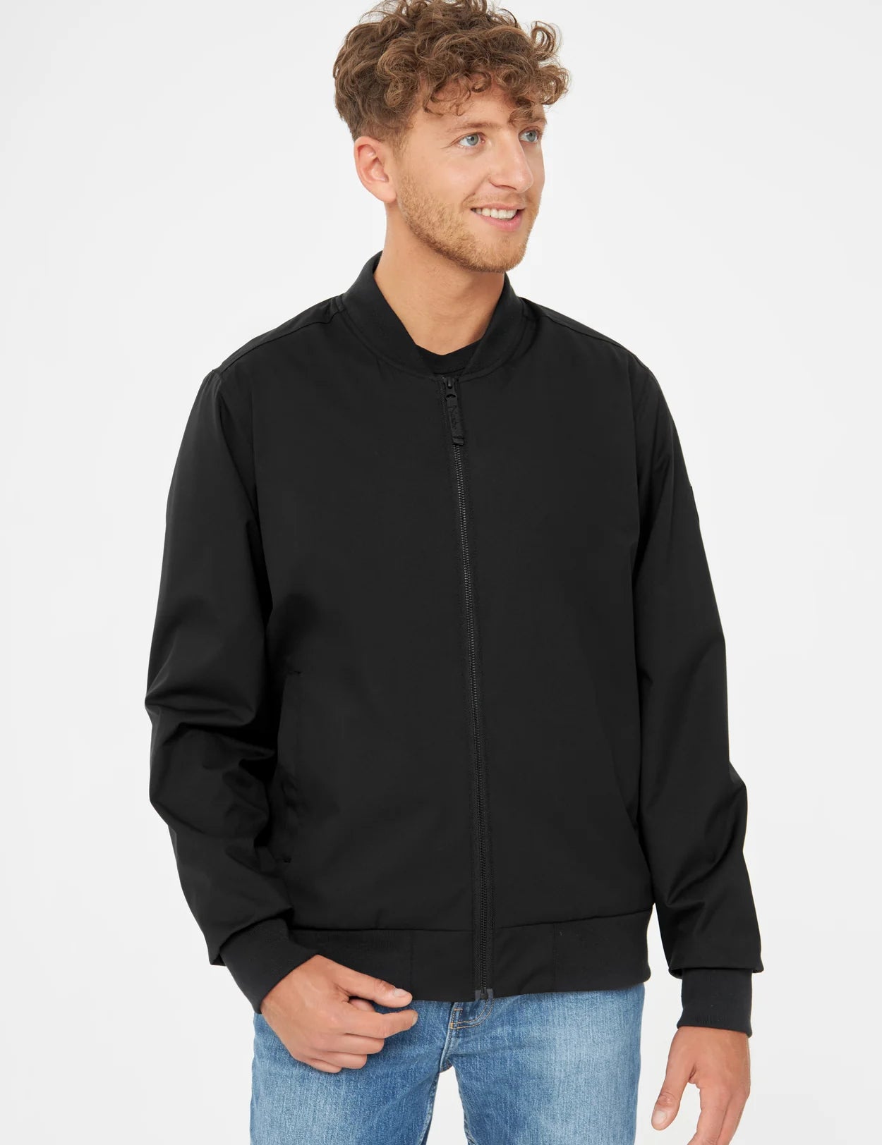 Mann mit schwarzer Jacke und blauen Jeans.