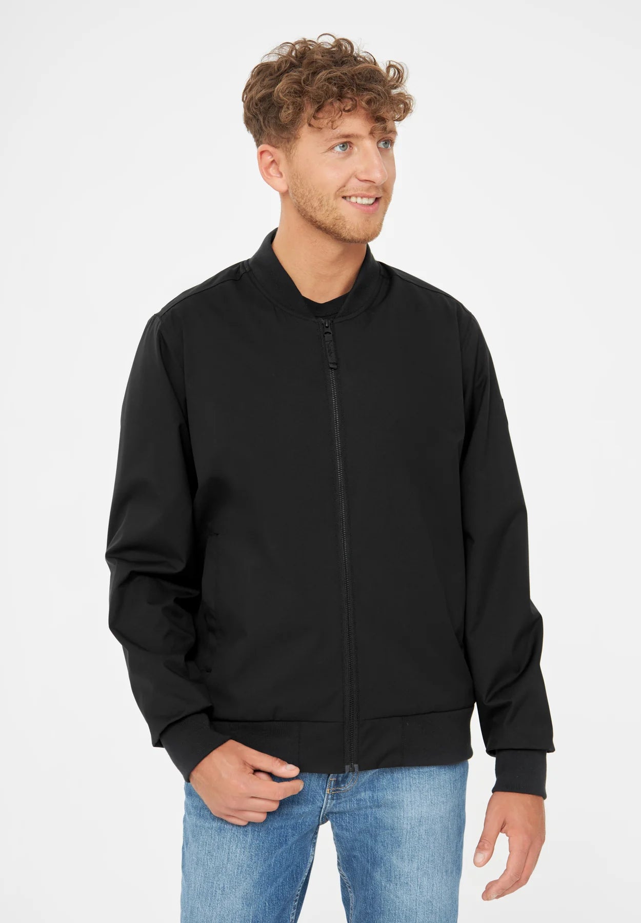 Mann mit schwarzer Jacke und blauen Jeans.
