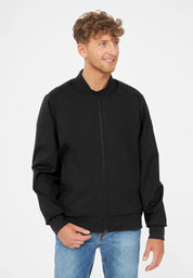 Mann mit schwarzer Jacke und blauen Jeans.