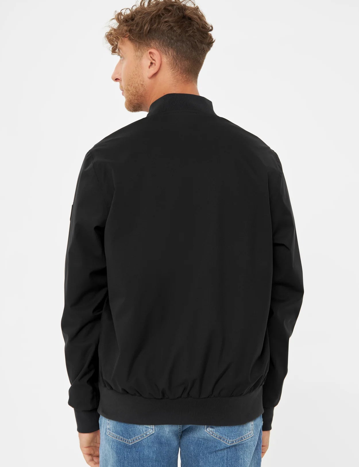 Mann trägt schwarze Jacke, Rückansicht.