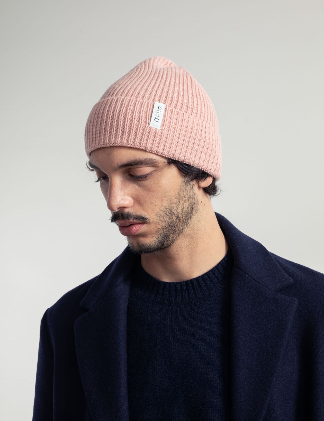 Mann mit rosa Mütze und marineblauem Mantel