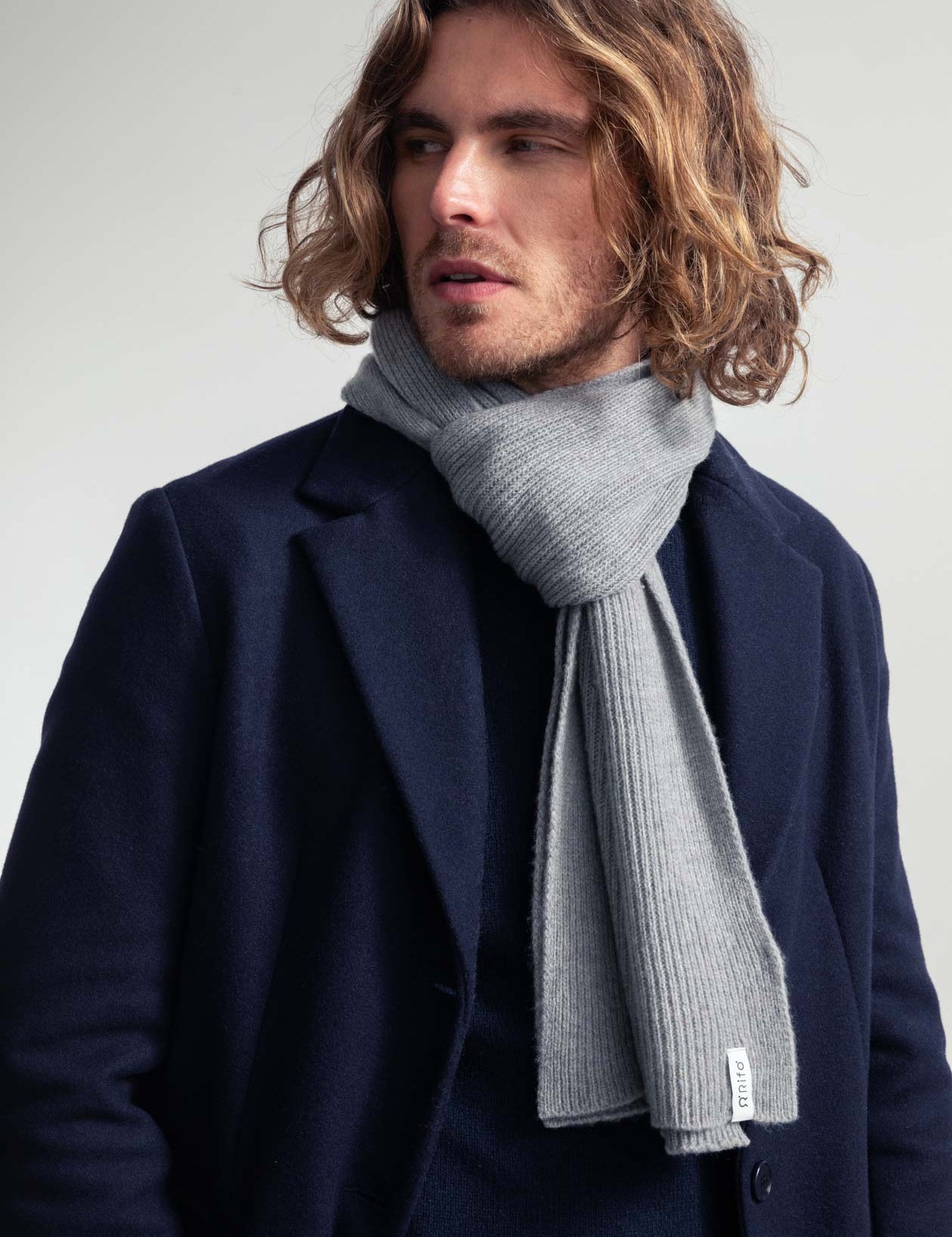 Mann mit Mantel und Schal blickt zur Seite