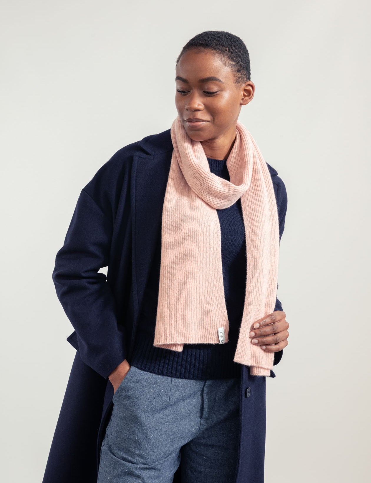 Frau in Mantel und rosa Schal lächelt