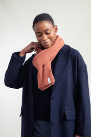 Frau in blauem Mantel mit rotem Schal