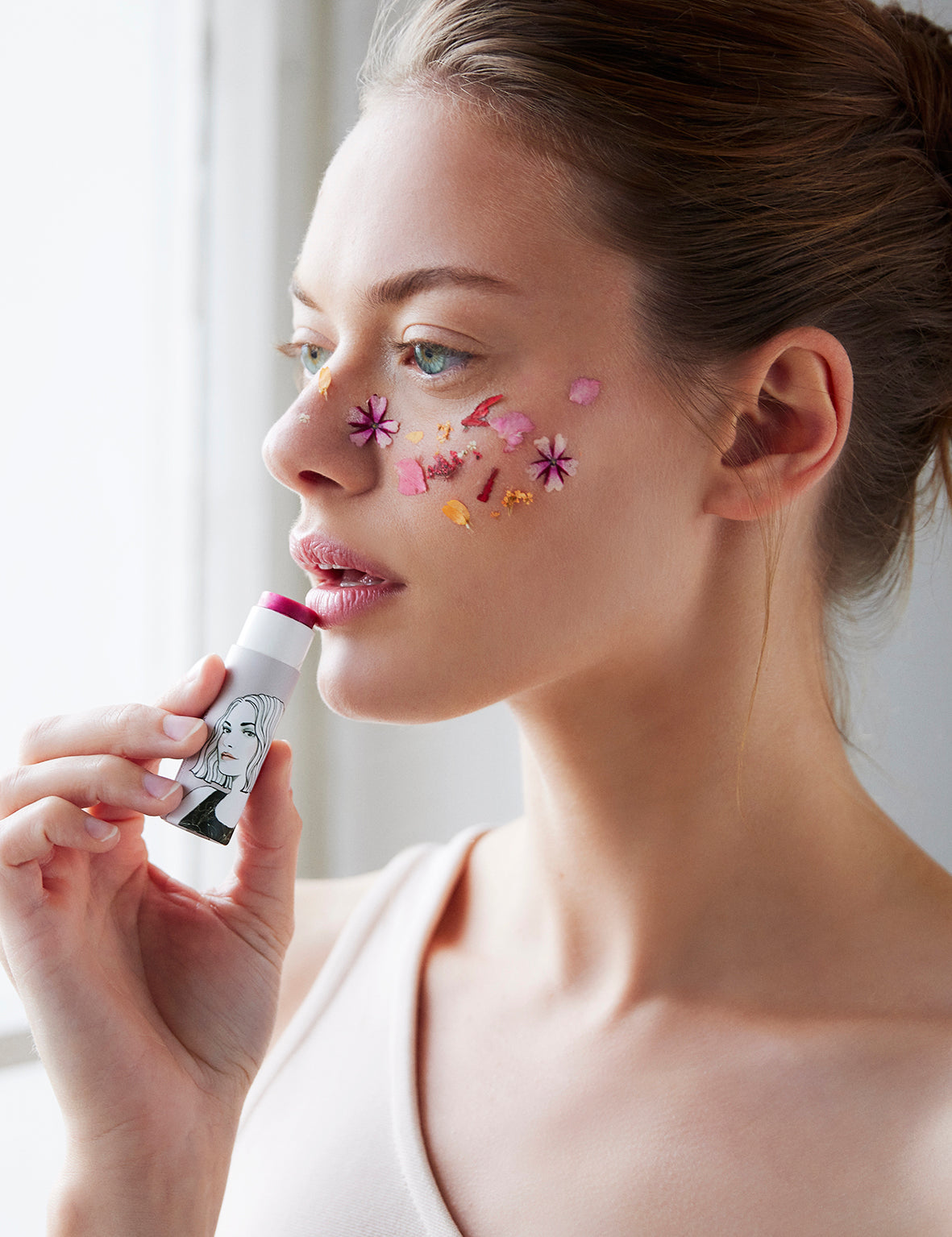 Frau trägt Lippenstift mit Blumen im Gesicht