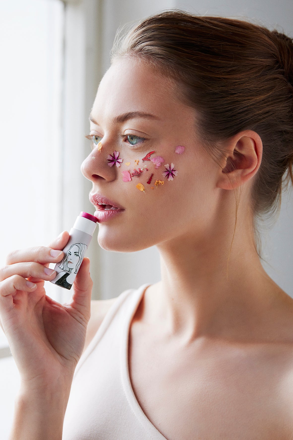 Frau trägt Lippenstift mit Blumen im Gesicht