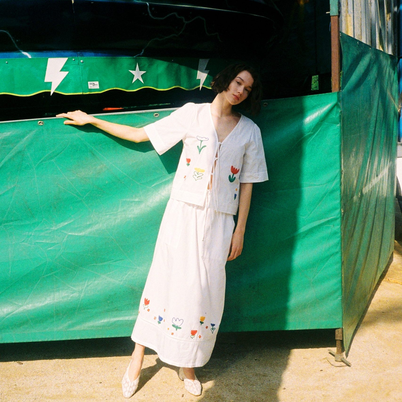 Frau in gemustertem Kleid vor Jahrmarktwagen