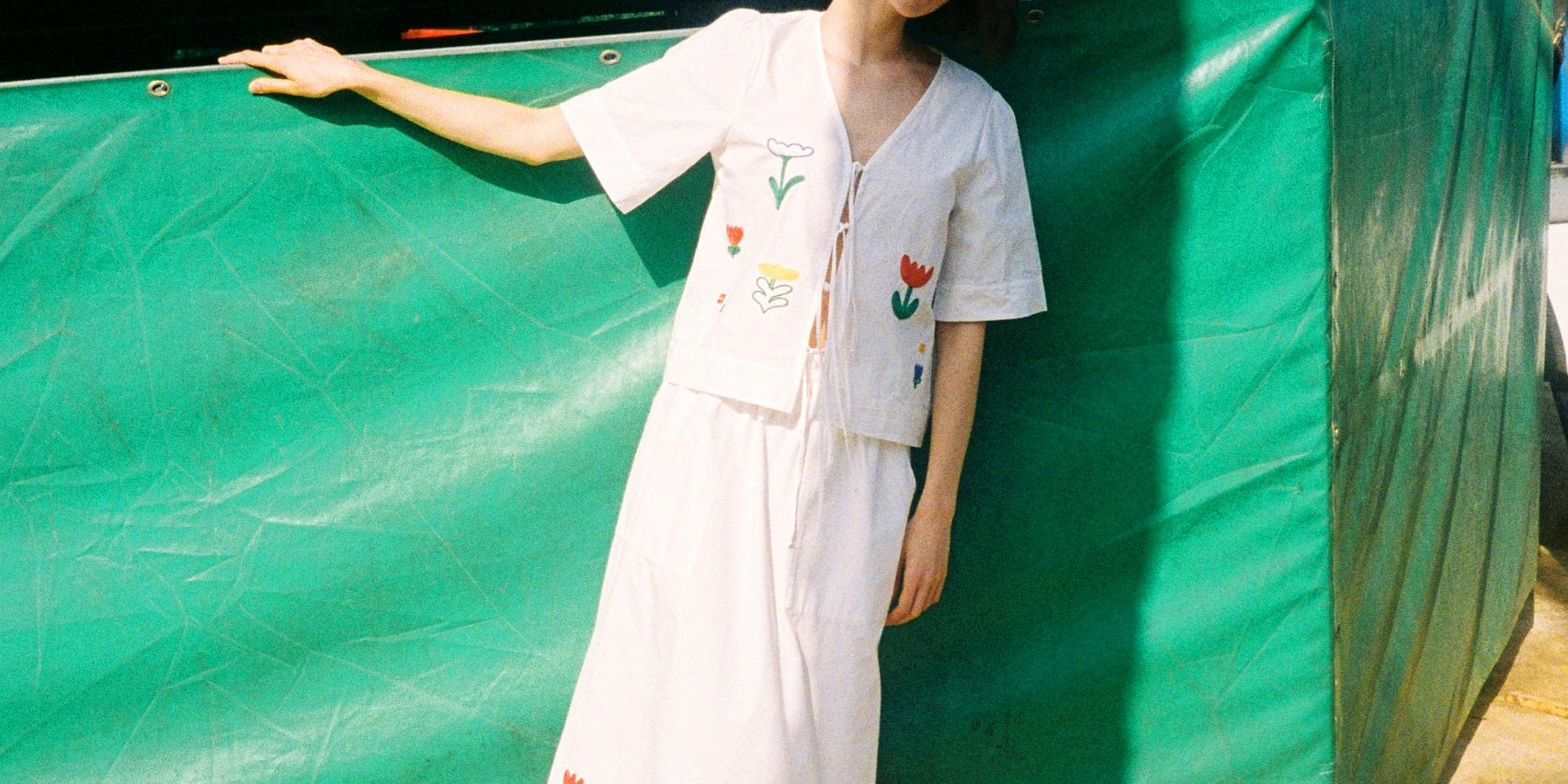 Frau in gemustertem Kleid vor Jahrmarktwagen