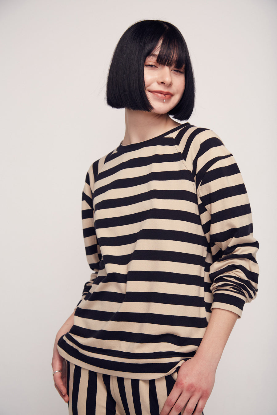 Frau mit schwarz-weiß gestreiftem Outfit lächelt